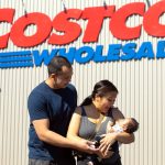 Angelo and Jona Sarmiento, along with baby Carlisle, stand in front of the Lake Stevens Costco where Jona went into labor with the couples first child on May 25. (Ryan Berry / The Herald)