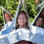 From left: Avery Martin D.C., Sarah Kotlerman D.C., and CEO Anna Martin, all of Averio Health Institute, wear giant cardboard vertebrae made out of banana boxes while demonstrating how they plan to claim the Guinness World Record for Largest Cardboard Costume. (Ryan Berry / The Herald)