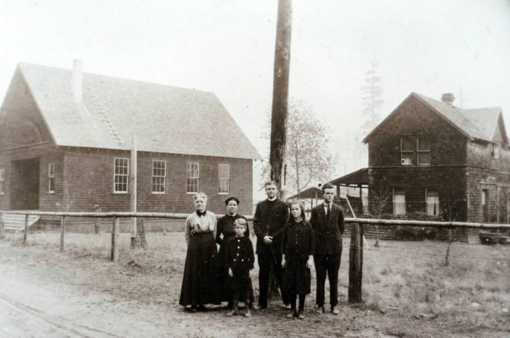 From left, Sarah Ellen Grubb, Delta Pearl Grubb Delong, James Leslie Delong, Frank L. Delong, Ester Delong and Jesse L. Delong in front of the Little Brown Church and the original house on the property in 1916.