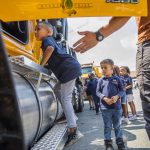 Michael Fekede, 5, climbs up into a truck during an event announcing funding for affordable child care slots held at Rise Up Academy on Thursday, July 6, 2023 in Everett, Washington. Rise Up Academy is one of a handful of child care facilities awarded funds to help increase child care slots. (Olivia Vanni / The Herald)