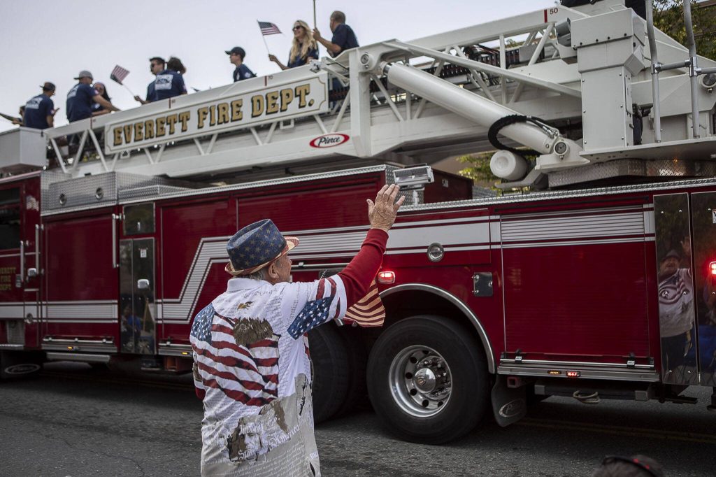 A man waves to the Everett Fire Department during the Everett 4th of July parade in downtown Everett, Washington on Tuesday, July 4, 2023. (Annie Barker / The Herald)