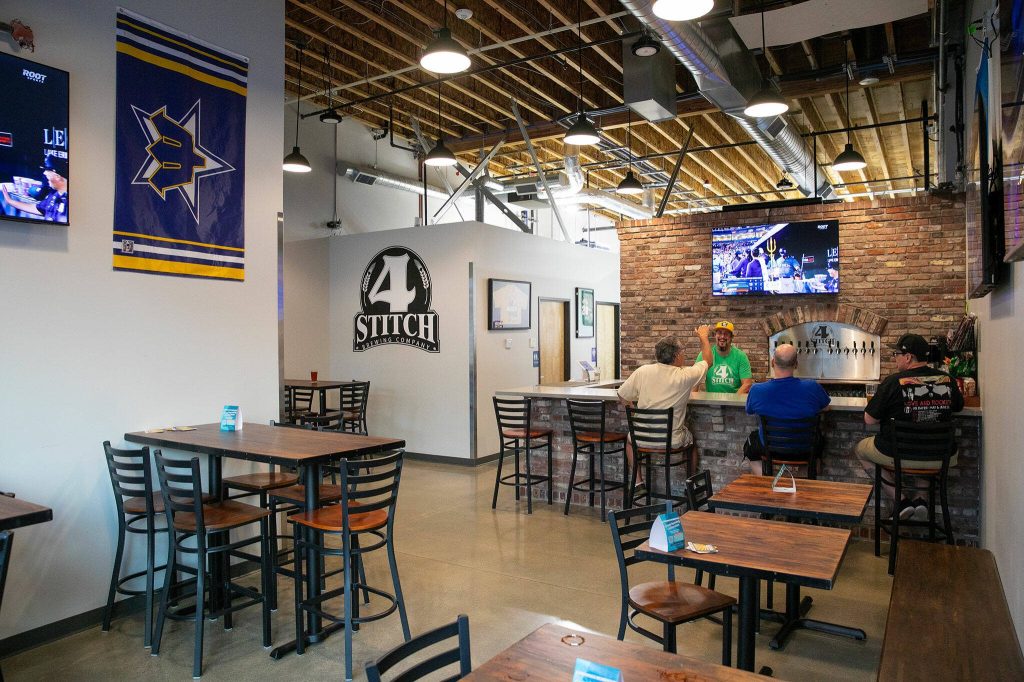 A few regulars hang at the bar as the night winds down at 4 Stitch Brewing Company on Friday, June 23, 2023, in Mill Creek, Washington. (Ryan Berry / The Herald)