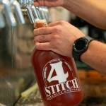 Owner Matt Pereira fills a growler for a customer at 4 Stitch Brewing Company on Friday, June 23, 2023, in Mill Creek, Washington. (Ryan Berry / The Herald)