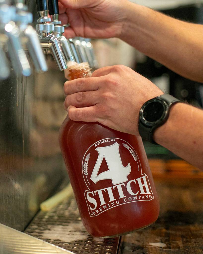 Owner Matt Pereira fills a growler for a customer at 4 Stitch Brewing Company on Friday, June 23, 2023, in Mill Creek, Washington. (Ryan Berry / The Herald)