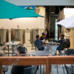 Patrons sit out on the patio and in the brewhouse at 4 Stitch Brewing Company on Friday, June 23, 2023, in Mill Creek, Washington. (Ryan Berry / The Herald)
