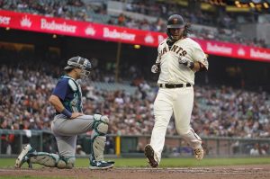 The Giants Brandon Crawford crosses home plate to score a run as Mariners catcher Cal Raleigh looks on in the third inning of a game on Wednesday in San Francisco. (AP Photo/Eric Risberg)