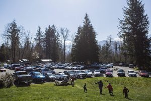 A family sits at a picnic table next to a full parking lot at the Wallace Falls trailhead on Saturday, March 21, 2020 in Gold Bar, Wa. (Olivia Vanni / The Herald)