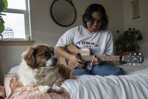 Thavoron plays his guitar at his apartment on Saturday, April 8, 2023 in Seattle, Washington. (Annie Barker / The Herald)