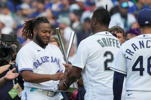The Blue Jays Vladimir Guerrero Jr. accepts his trophy from former Seattle Mariner Ken Griffey Jr. after winning the MLB All-Star Home Run Derby on Monday night in Seattle. (AP Photo/Ted Warren)