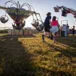 Kids run on the grass during the Kla Ha Ya Days carnival at Harvey Field in Snohomish, Washington on Thursday, July 13, 2023. (Annie Barker / The Herald)