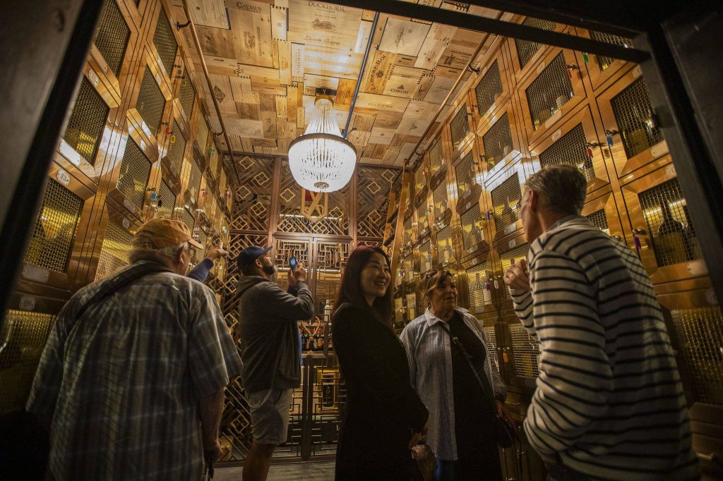 People explore inside the wine locker vault at the Muse Whiskey & Coffee Bar on Wednesday, July 12, 2023 in Everett, Washington. (Olivia Vanni / The Herald)