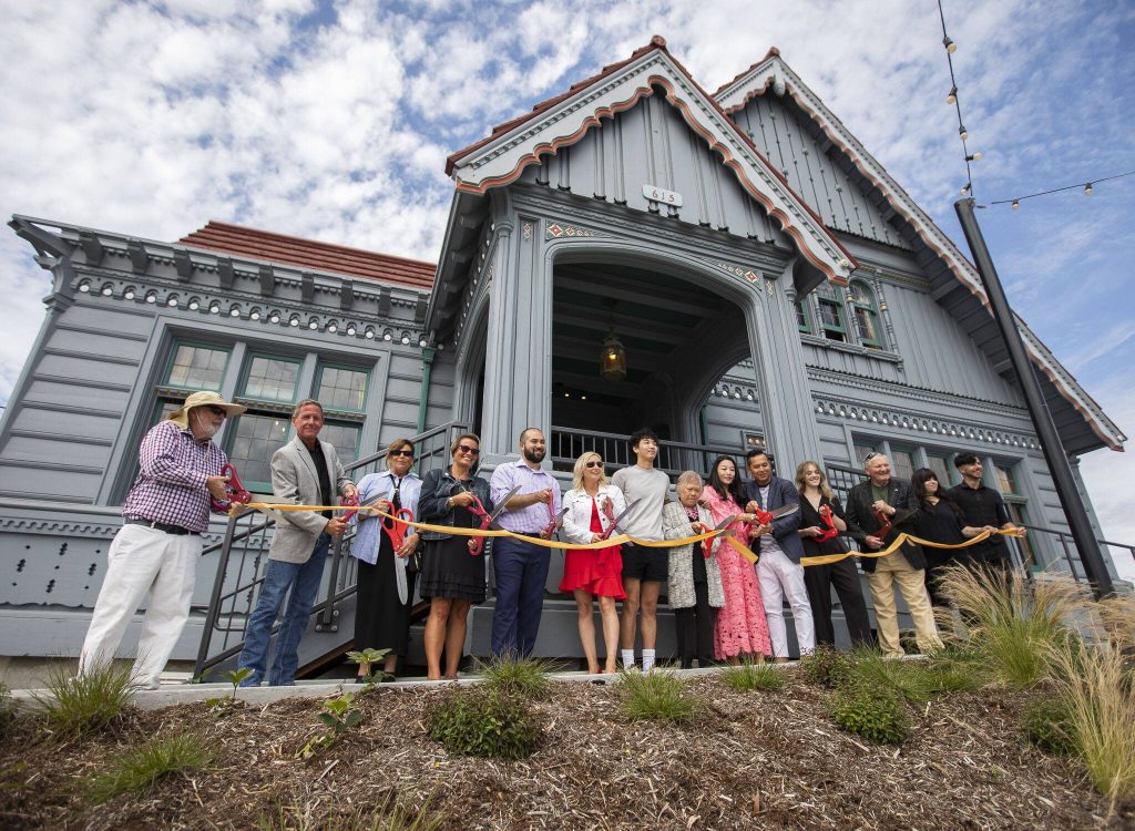 Jack and Jin Ng along with Everett and Port of Everett officials cut the ribbon at the grand opening of the Muse Whiskey & Coffee Bar in the 100-year-old Weyerhaeuser building on Wednesday, July 12, 2023 in Everett, Washington. (Olivia Vanni / The Herald)