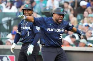 The National Leagues Elias Díaz, of the Colorado Rockies, celebrates his two run home run with Ozzie Albies, of the Atlanta Braves, during the eighth inning of the MLB All-Star game on Tuesday in Seattle. (AP Photo/Ted S. Warren)