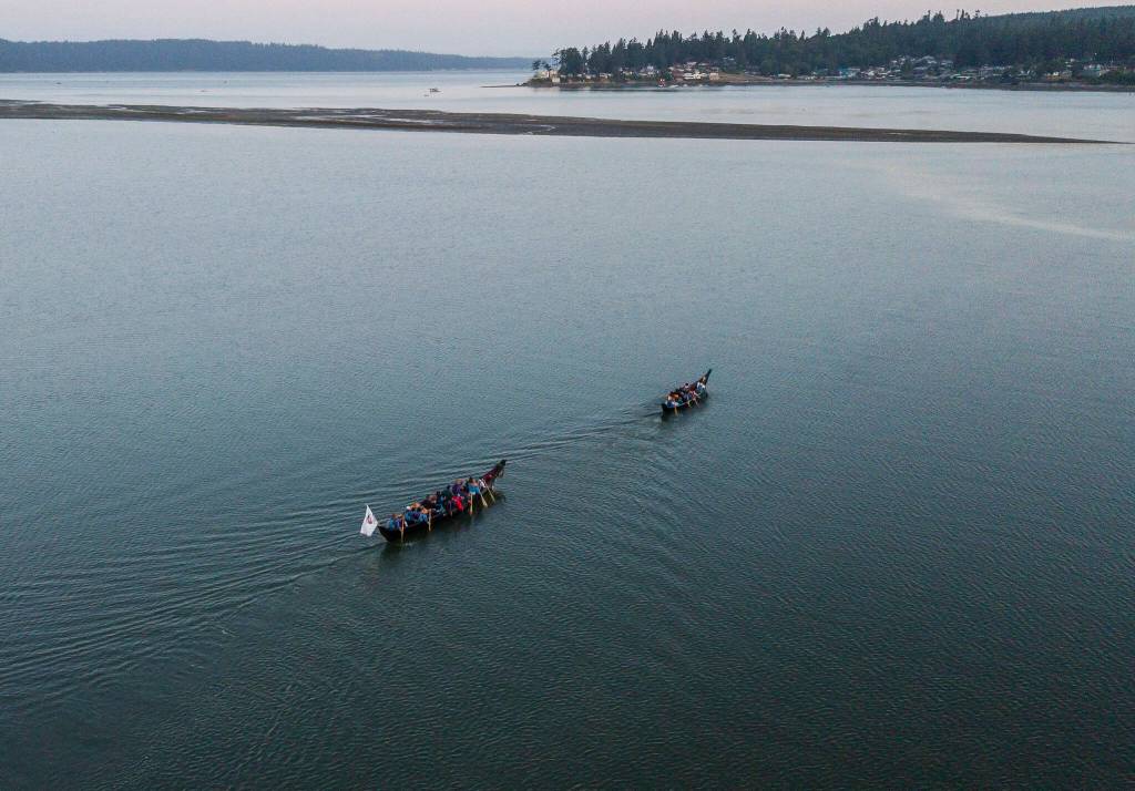 Two canoes make their way out of Tulalip Bay and into Possession Sound on Friday, July 28, 2023 in Tulalip, Washington. (Olivia Vanni / The Herald)