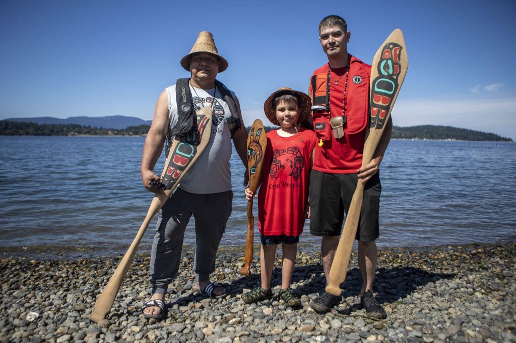 Left to right, Doug Chilton, 58, of the Tlingit tribe, and his sons Richard, 10, and Micheal, 32, pose for a photo during the 2023 Washington Tribes Canoe Journey in Bellingham, Washington on Sunday, July 23, 2023. (Annie Barker / The Herald)
