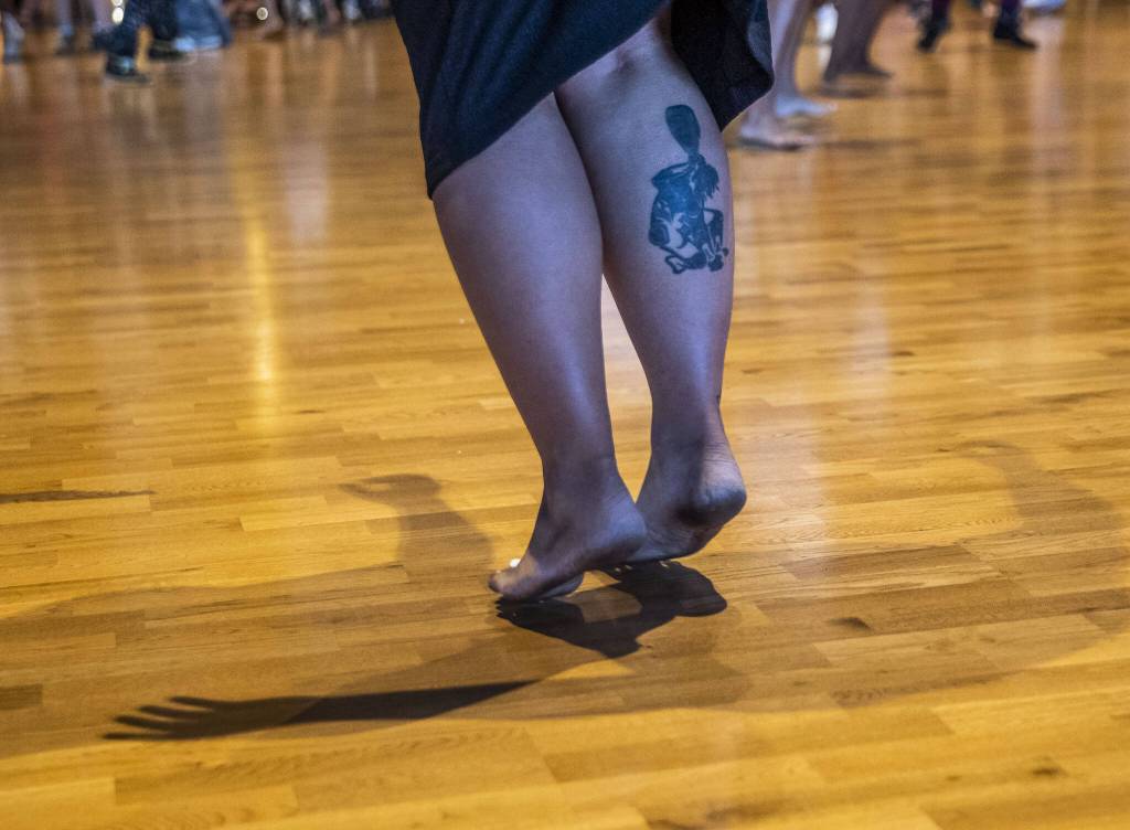 A woman jumps off the floor during protocol at the Tulalip Gathering Hall on Thursday, July 27, 2023. (Olivia Vanni / The Herald)