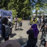 Media and community members listen as Lynnwood City Councilmember Joshua Binda speaks during a NAACP Snohomish County press conference at Lynnwood City Hall in Lynnwood, Washington on Thursday, July 20, 2023. (Annie Barker / The Herald)
