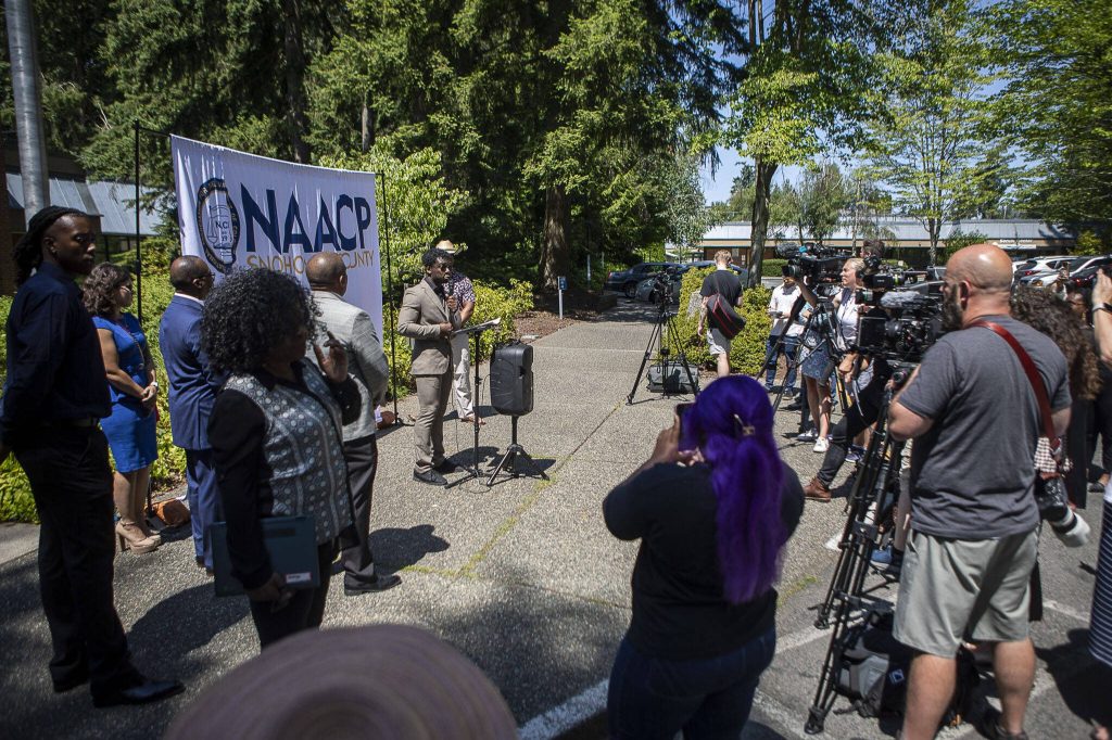 Media and community members listen as Lynnwood City Councilmember Joshua Binda speaks during a NAACP Snohomish County press conference at Lynnwood City Hall in Lynnwood, Washington on Thursday, July 20, 2023. (Annie Barker / The Herald)