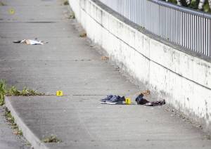 A pair of shoes and a blood covered piece of denim is marked by as evidence at the scene of a shooting on Smith Avenue on Tuesday, July 18, 2023 in Everett, Washington. (Olivia Vanni / The Herald)