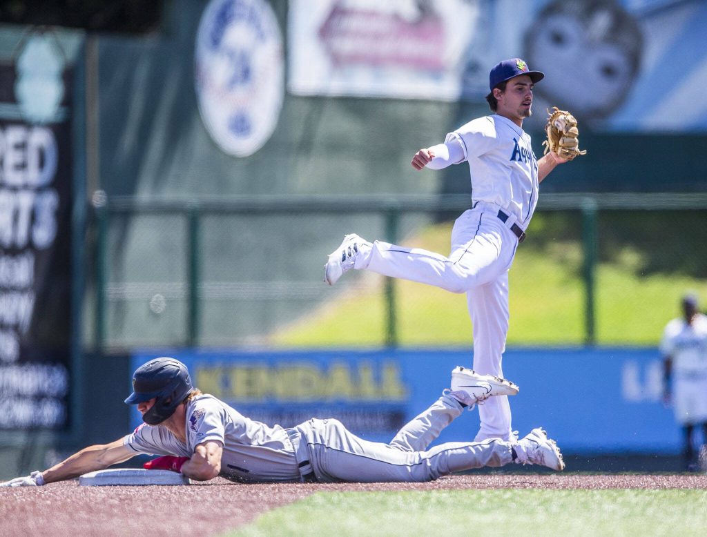 AquaSoxs Cole Young leaps in the air to catch a wild throw during the game against the Tri-City Dust Devils on Wednesday, July 19, 2023 in Everett, Washington. (Olivia Vanni / The Herald)