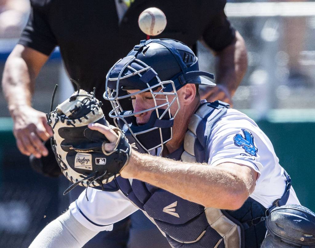 A wild pitch flies over the head of AquaSox catcher Andrew Miller during the game against the Tri-City Dust Devils on Wednesday, July 19, 2023 in Everett, Washington. (Olivia Vanni / The Herald)
