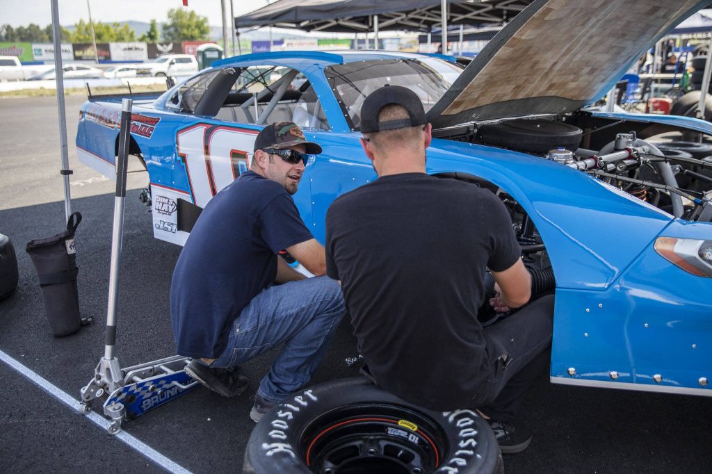 Owen Riddle, left, works on his car during practice for Summer Showdown at Evergreen Speedway on Thursday in Monroe. (Olivia Vanni / The Herald)
