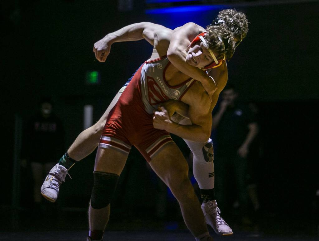 Arlingtons Dustin Baxter hangs on the back of Stanwoods Ryder Bumgarner during the 170-pound match on Jan. 24 in Arlington. (Olivia Vanni / The Herald)