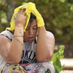 Kristin Peterson tries to cool off with a cold bandana at Sonrise Homeless Navigation Center in Austin, Texas, July 11, during a heat advisory with temperatures that topped 100 degrees. (Jay Janner / Austin American-Statesman)
