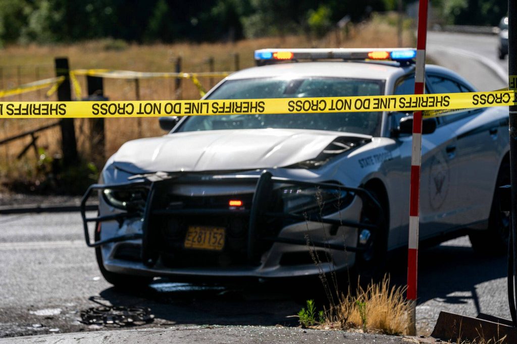 Police tape stretches in front of a Oregon State Troopers vehicle Friday at the Melrose Country Store in Roseburg, Oregon. The vehicle was damaged in a Friday morning chase. (Will Geschke/The News-Review)