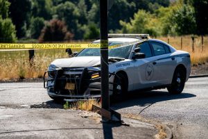 Police tape stretches in front of a Oregon State Trooper's vehicle Friday at the Melrose Country Store in Roseburg, Oregon. The vehicle was damaged in a Friday morning chase. (Will Geschke/The News-Review)