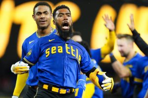 Seattle Mariners' Teoscar Hernandez, second from left, celebrates hitting a walk-off single for a 3-2 win over the Toronto Blue Jays as teammate Julio Rodriguez, left, looks on after a baseball game, Friday, July 21, 2023, in Seattle. (AP Photo/Lindsey Wasson)