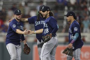 The Mariners Eugenio Suarez (28) high fives Ty France (left) in celebration after beating the Twins in a game on Tuesday in Minneapolis. (AP Photo/Stacy Bengs)