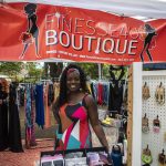 Finess4U Boutique Owner Tiffany Miller poses for a photo with her booth during the Nubian Jam at Forest Park in Everett, Washington on Saturday, July 29, 2023. (Annie Barker / The Herald)