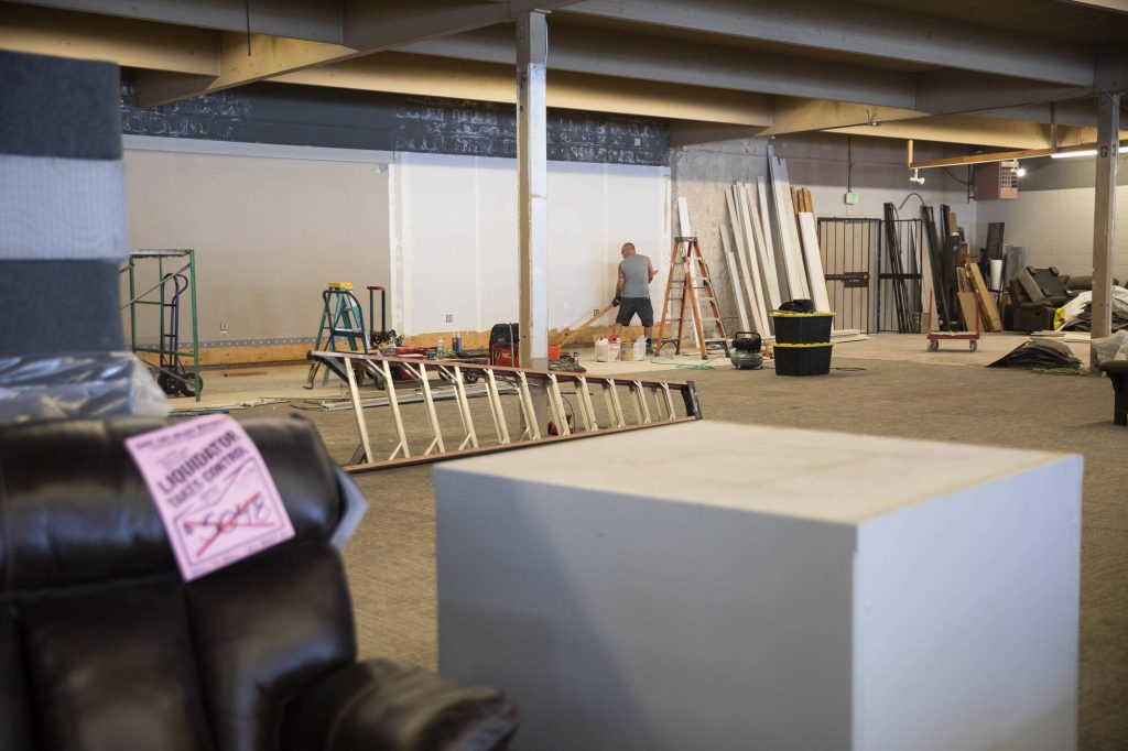 A worker begins remodeling parts of the Behars furniture building on Thursday, Aug. 24, 2023 in Everett, Washington. (Olivia Vanni / The Herald)