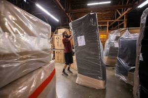 Tanner Mock begins unwrapping new furniture that has been delivered on Thursday, Aug. 24, 2023 in Everett, Washington. (Olivia Vanni / The Herald)