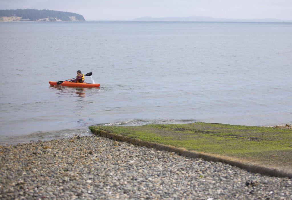 A kayaker launches from the Maple Grove Boat Launch on Wednesday, June 28, 2023 in Camano Island, Washington. (Olivia Vanni / The Herald)