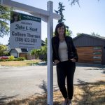 Real estate agent Colleen Thorsen poses for a photo in front of a home in Brier, Washington on Friday, July 28, 2023. (Annie Barker / The Herald)