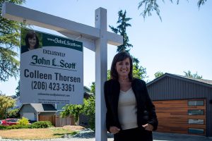 Real estate agent Colleen Thorsen poses for a photo in front of a home in Brier, Washington on Friday, July 28, 2023. (Annie Barker / The Herald)