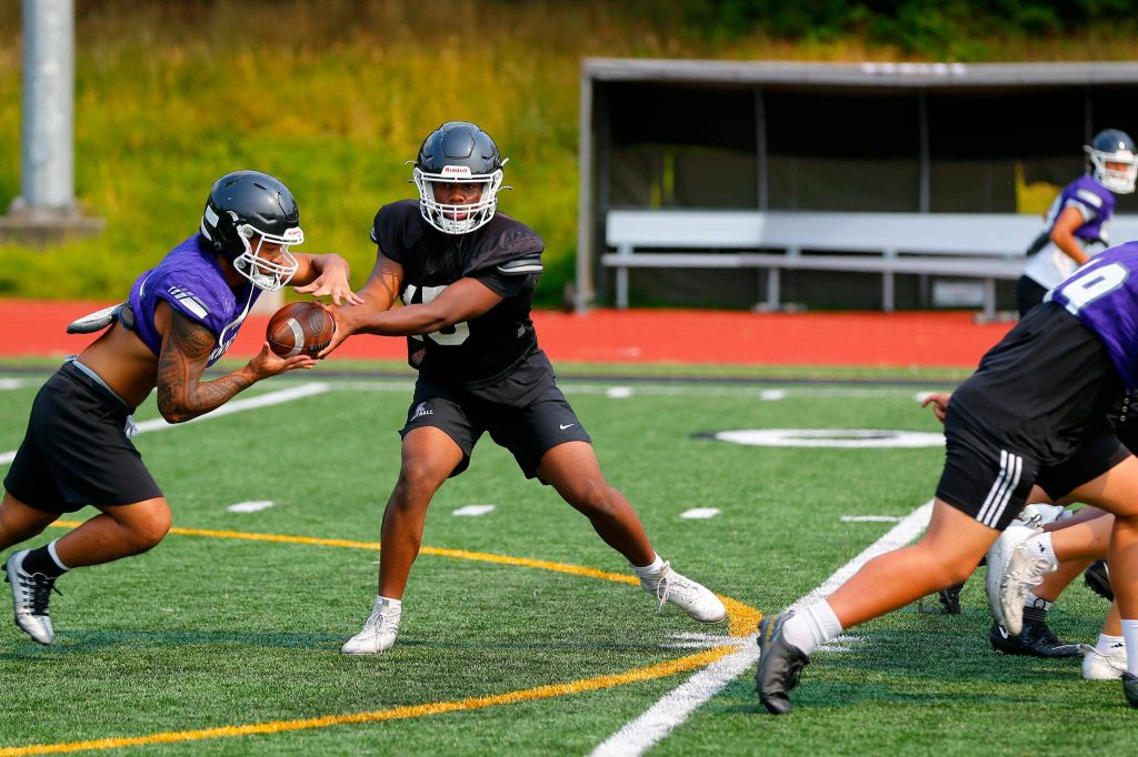 The Kamiak offense runs through drills during a team practice Wednesday at Kamiak High School in Mukilteo. (Ryan Berry / The Herald)