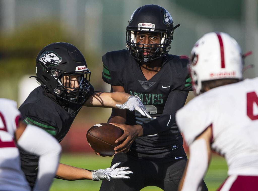 Jacksons Edonyas Abebe hands the ball off during a game against Cascade on Sept. 23, 2022 in Everett. (Olivia Vanni / The Herald)