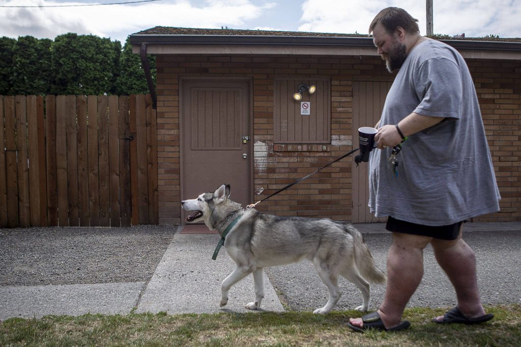 Marc Boucher walks his wife Amandas service dog Loki. Amanda Boucher has health problems that leave her disabled. (Annie Barker / The Herald)