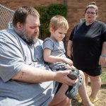 Marc Boucher, left, helps Maverick Boucher, 4, put on his shoes as Amanda Boucher, right, stands by to assist at the Interfaith Association of Northwest Washington located at 2520 Cedar Street in Everett, Washington on Sunday, July 30, 2023. (Annie Barker / The Herald)