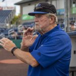 Everett Merchants manager Harold Pyatte gives a signal during a game on Friday at Funko Field in Everett. (Annie Barker / The Herald)
