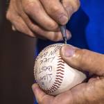 Everett Merchants manager Harold Pyatte signs a ball Liam, best of luck in Baseball - Harold Pyatte after his final game on Friday at Funko Field in Everett. (Annie Barker / The Herald)