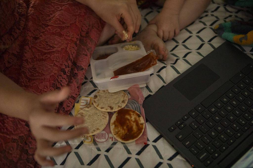 Mia Boucher, 9, snacks on a Lunchables with Karter Boucher, 2, at a motel in Arlington, Washington, on Thursday, Aug. 10, 2023. (Annie Barker / The Herald)