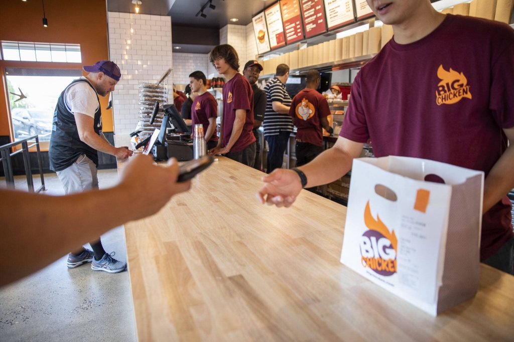 People pick up food at Big Chicken on Thursday, Aug. 10, 2023 in Mukilteo, Washington. (Olivia Vanni / The Herald)