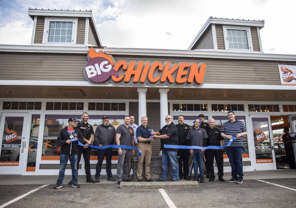 Community members and store management cut the ribbon at the grand opening of Big Chicken on Thursday, Aug. 10, 2023 in Mukilteo, Washington. (Olivia Vanni / The Herald)