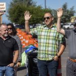 People involved with the project raise their hands during a ribbon cutting ceremony to celebrate the completion of the 196th Street SW Improvement Project near the 196th and 44th Ave West intersection in Lynnwood, Washington on Tuesday, Aug. 15, 2023. (Annie Barker / The Herald)