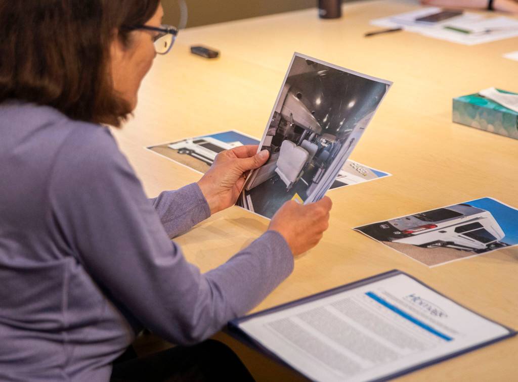 U.S. Congresswoman Suzan DelBene looks through photos of one of the vehicles Homage is hoping to purchase on Monday, Aug. 14, 2023 in Lynnwood, Washington. (Olivia Vanni / The Herald)