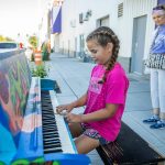 Kenzie Norton, 10, plays a part of the song "Baby Bumblebee" on piano painted by Amber Forrest in front of the Imagine Children’s Museum on Wednesday, Aug. 16, 2023 in Everett, Washington. (Olivia Vanni / The Herald)